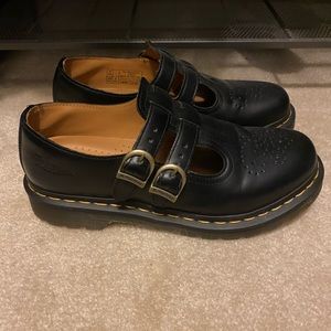 Black Dr. Martens buckle shoes with yellow stripe